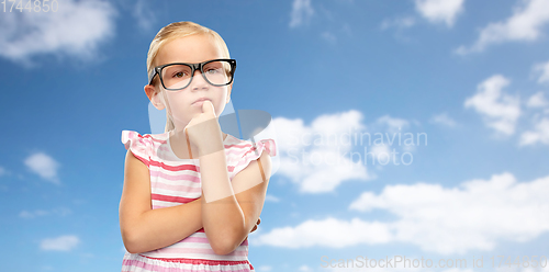 Image of cute little girl in black glasses thinking