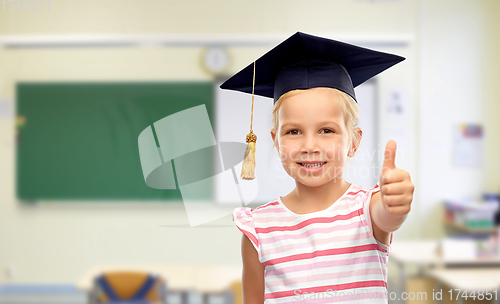 Image of girl in mortarboard showing thumbs up at school