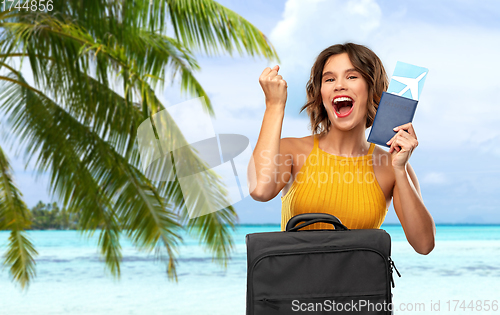 Image of happy woman with ticket and travel bag on beach