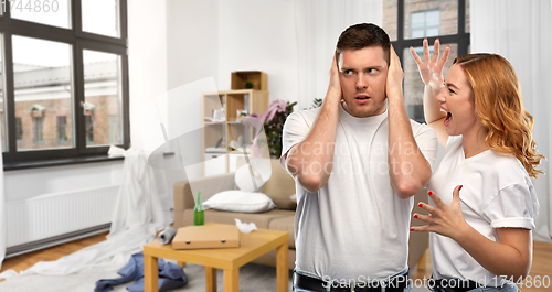 Image of couple having argument over messy home room