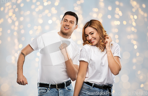 Image of portrait of happy couple in white t-shirts dancing