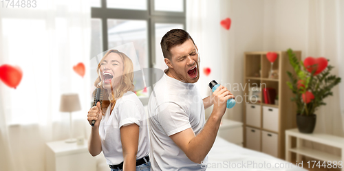 Image of couple singing to hairbrush and lotion at home