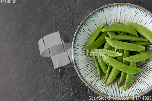 Image of peas in bowl on wet slate stone background