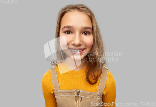 Image of smiling teenage girl over grey background