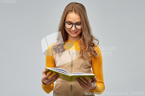Image of teenage student girl in glasses reading book
