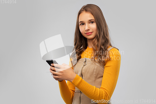 Image of smiling teenage girl using smartphone