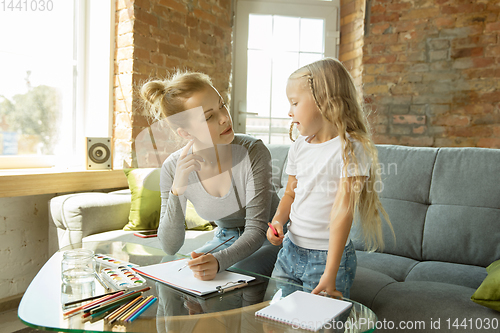 Image of Teacher and little girl, or mom and daughter. Homeschooling concept