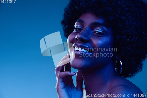 Image of Portrait of female high fashion model in neon light