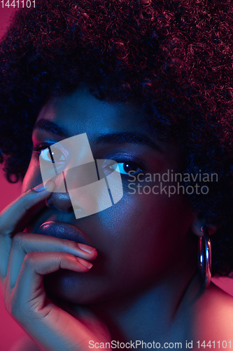 Image of Portrait of female high fashion model in neon light