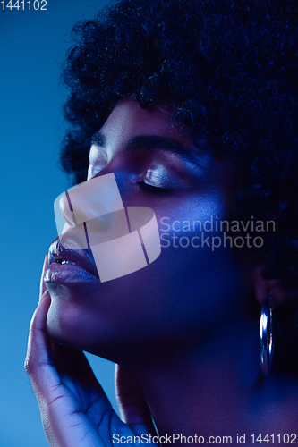 Image of Portrait of female high fashion model in neon light