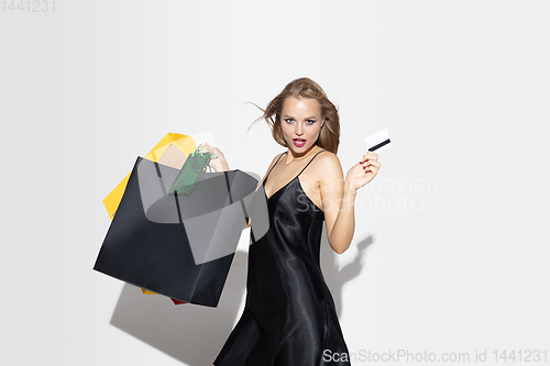 Image of Young woman in dress shopping on white background