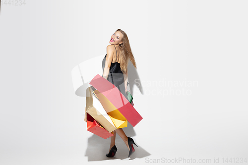 Image of Young woman in dress shopping on white background