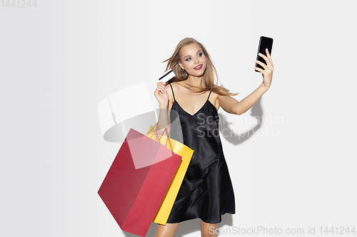 Image of Young woman in dress shopping on white background