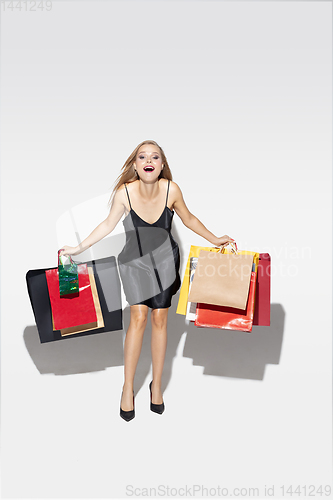 Image of Young woman in dress shopping on white background