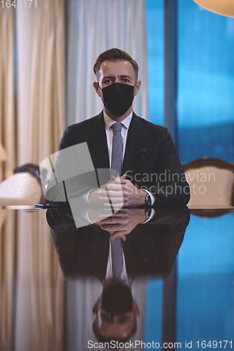 Image of business man wearing protective face mask at luxury office