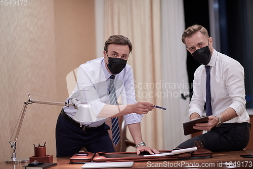 Image of business people wearing crona virus protection face mask on meeting