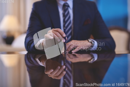 Image of corporate businessman at luxury office pen holding 