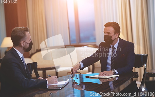 Image of business people wearing crona virus protection face mask on meeting