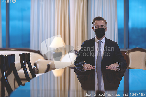 Image of business man wearing protective face mask at luxury office