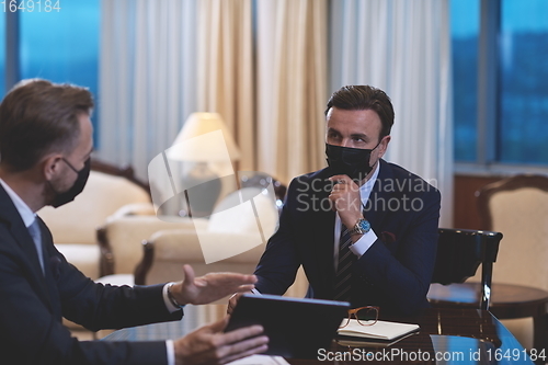 Image of business people wearing crona virus protection face mask on meeting