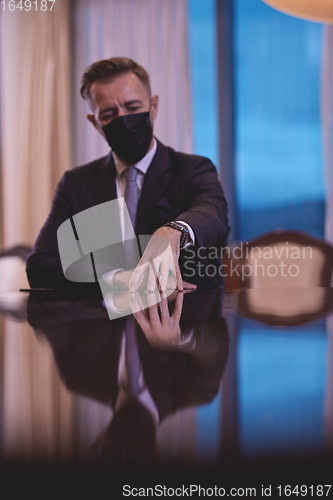 Image of business man wearing protective face mask at luxury office