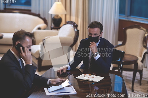 Image of business people wearing crona virus protection face mask on meeting