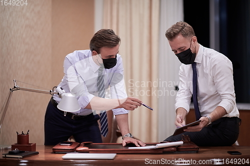 Image of business people wearing crona virus protection face mask on meeting