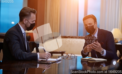 Image of business people wearing crona virus protection face mask on meeting