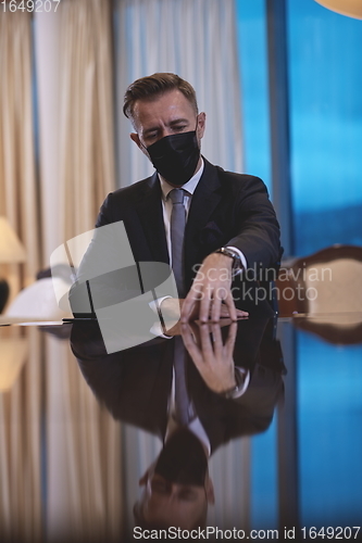 Image of business man wearing protective face mask at luxury office