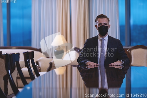 Image of business man wearing protective face mask at luxury office