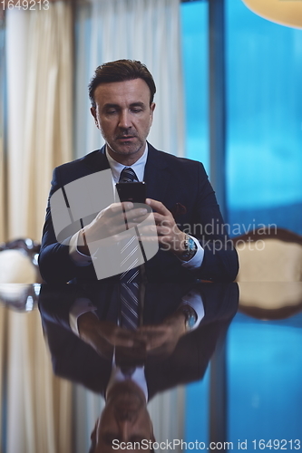 Image of business man using smart phone at luxury office