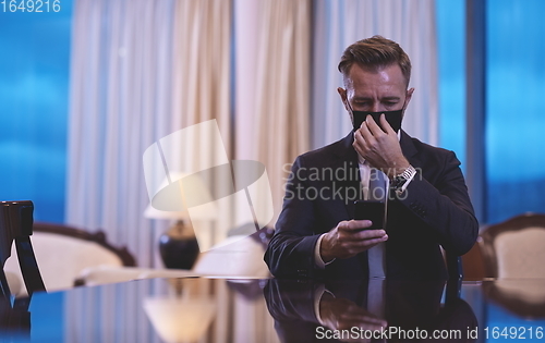 Image of business man using smart phone at luxury office wearing face mask