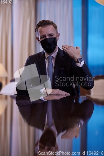 Image of business man wearing protective face mask at luxury office