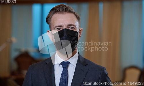 Image of business man wearing protective face mask at office