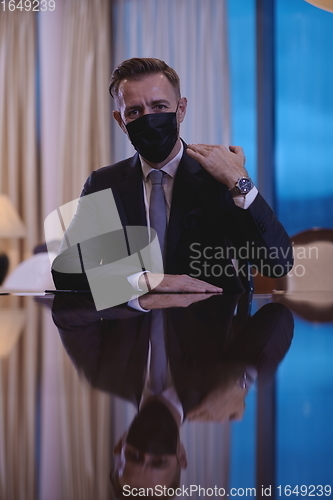 Image of business man wearing protective face mask at luxury office