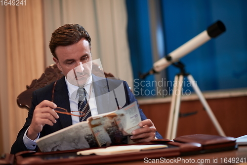 Image of corporate business man at office reading magazine