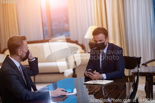 Image of business people wearing crona virus protection face mask on meeting