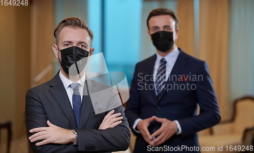 Image of business team wearing crona virus protection face mask