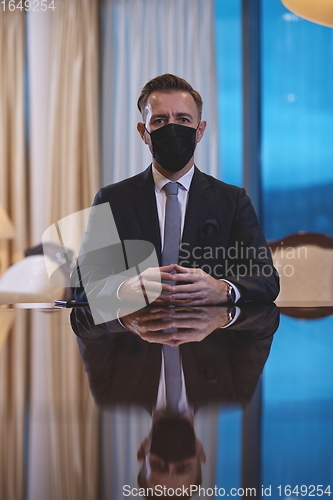 Image of business man wearing protective face mask at luxury office