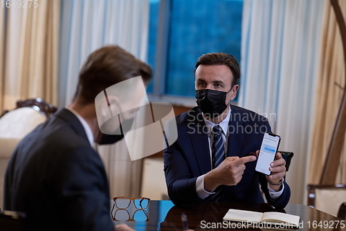 Image of business people wearing crona virus protection face mask on meeting