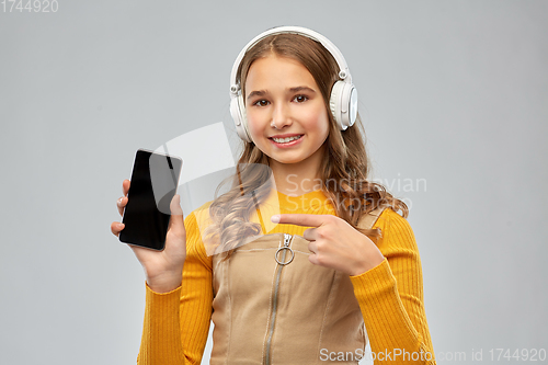 Image of teenage girl in headphones showing smartphone