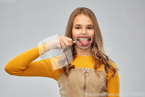 Image of teenage girl shows tongue through magnifying glass