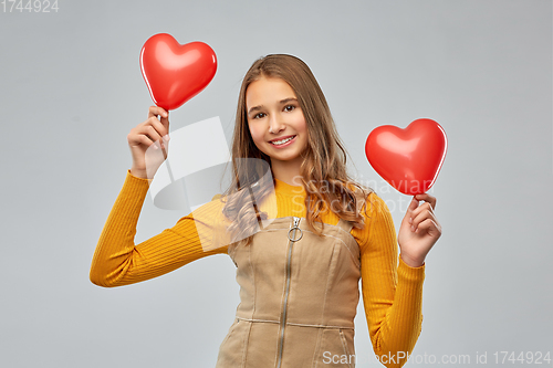 Image of happy teenage girl with red heart-shaped balloons