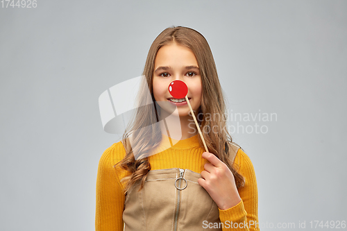 Image of smiling teenage girl with red clown nose