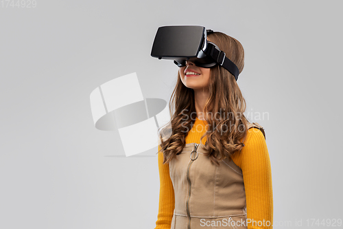 Image of teenage girl in vr glasses over grey background