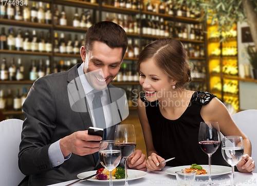 Image of smiling couple eating main course at restaurant