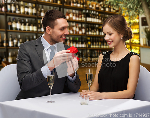 Image of happy couple with gift box at restaurant