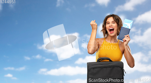 Image of happy young woman with air ticket and travel bag