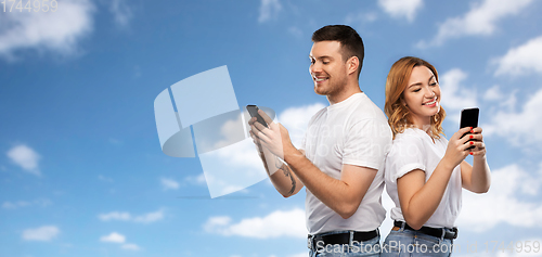 Image of happy couple in white t-shirts with smartphones