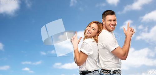 Image of couple in white t-shirts shirts making gun gesture